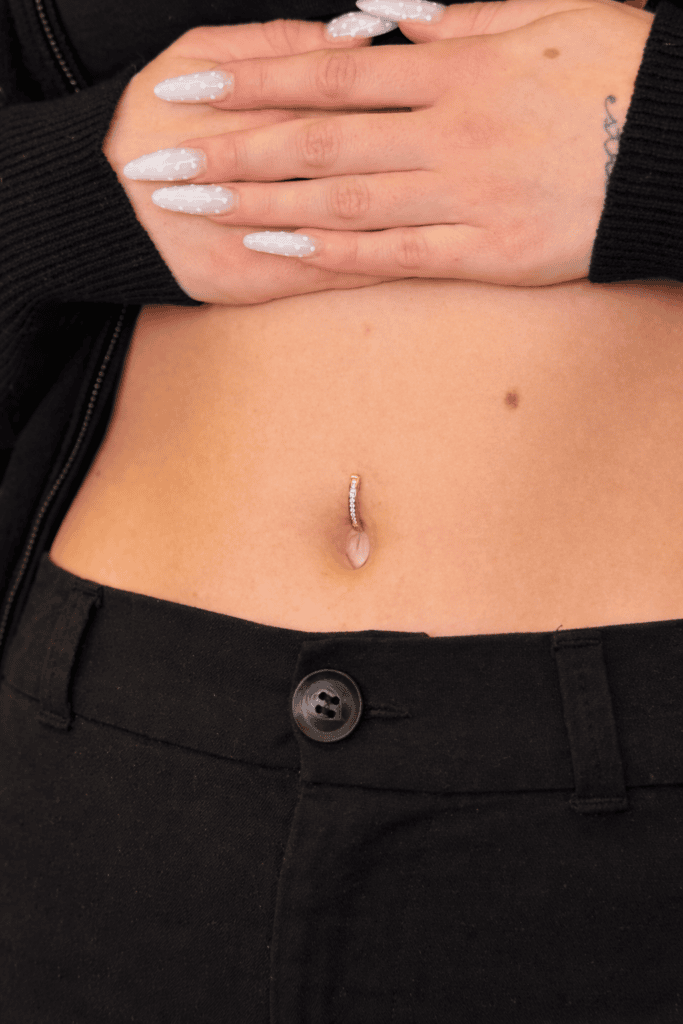 Piercing all’ombelico con gioiello dorato minimal, esempio professionale